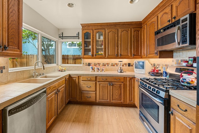 4595 Aragon Dr, Carpinteria, CA 93013 - kitchen with appliances with stainless steel finishes, light wood finished floors, decorative backsplash, brown cabinets, and recessed lighting
