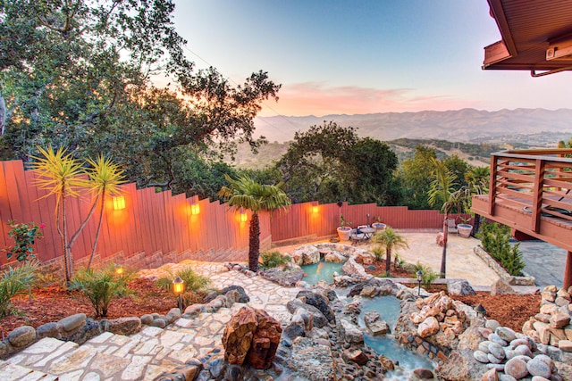 1110 Deer Canyon Rd, Arroyo Grande, CA 93420 - yard at dusk featuring a fenced backyard, a patio, and a deck with mountain view
