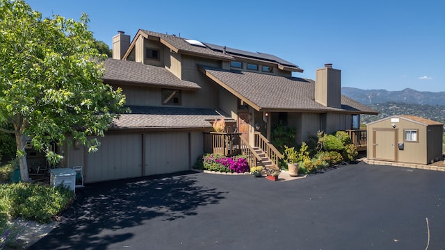1010 Portesuello Ave, Santa Barbara, CA 93105 - townhome / multi-family property with a chimney, asphalt driveway, roof mounted solar panels, roof with shingles, and a garage