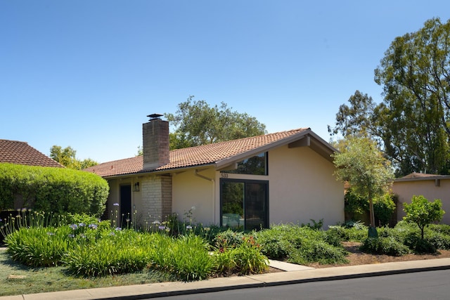 533 N La Cumbre Rd, Santa Barbara, CA 93110 - view of side of home with a tiled roof, a chimney, and stucco siding