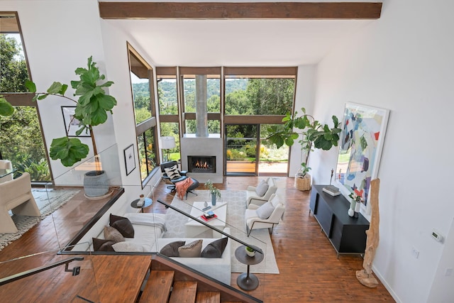 2031 Cielito Ln, Santa Barbara, CA 93105 - sunken living room featuring wood finished floors, a warm lit fireplace, expansive windows, and beamed ceiling