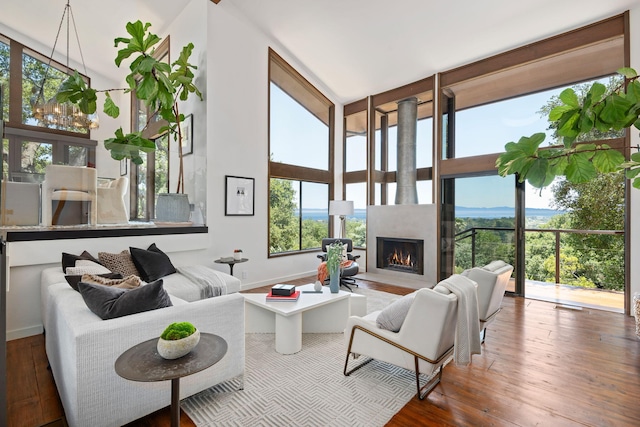 2031 Cielito Ln, Santa Barbara, CA 93105 - living room featuring hardwood / wood-style floors, baseboards, a lit fireplace, and a towering ceiling
