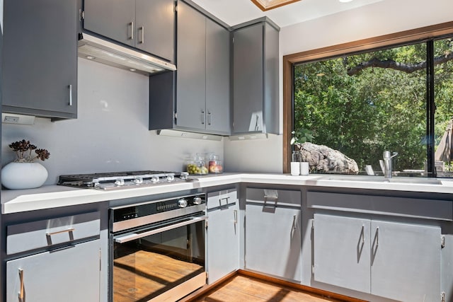 2031 Cielito Ln, Santa Barbara, CA 93105 - kitchen with appliances with stainless steel finishes, under cabinet range hood, light countertops, and gray cabinetry