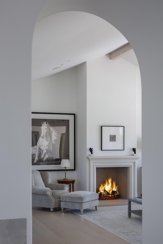 2720 Montecito Ranch Pl, Summerland, CA 93067 - living room featuring arched walkways, a lit fireplace, and wood finished floors