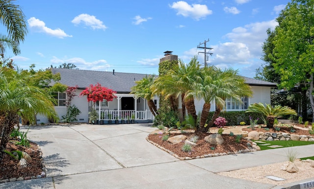 7659 Dartmoor Ave, Goleta, CA 93117 - view of front of property with a porch, driveway, a chimney, and stucco siding