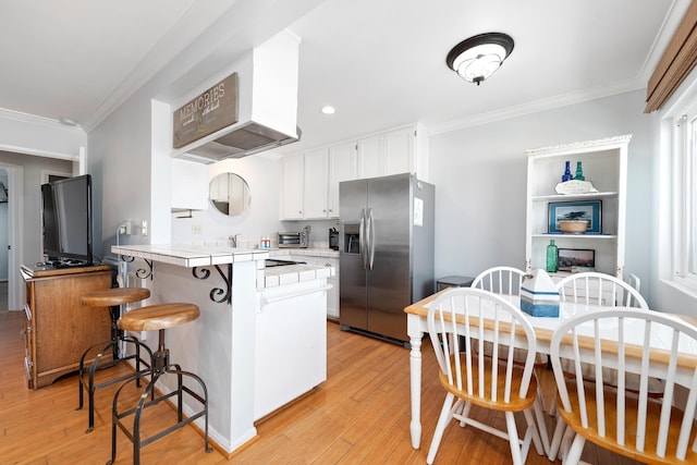 4975 Sandyland Rd Unit 302, Carpinteria, CA 93013 - kitchen featuring stainless steel refrigerator with ice dispenser, a peninsula, ornamental molding, light wood-type flooring, and white cabinets