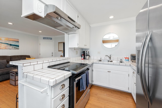 4975 Sandyland Rd Unit 302, Carpinteria, CA 93013 - kitchen with appliances with stainless steel finishes, ornamental molding, ventilation hood, tile counters, and a sink