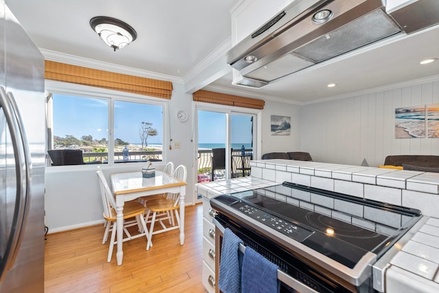 4975 Sandyland Rd Unit 302, Carpinteria, CA 93013 - kitchen with tile countertops, freestanding refrigerator, electric range, ornamental molding, and light wood finished floors