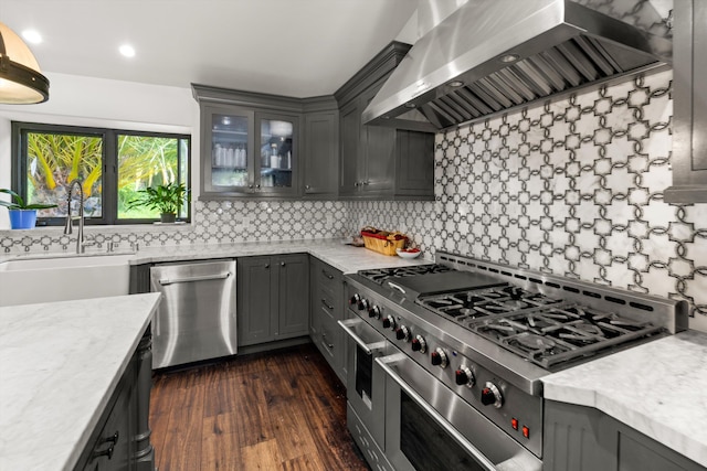 1151 Glenview Rd, Montecito, CA 93108 - kitchen with stainless steel appliances, wall chimney range hood, decorative backsplash, dark wood-type flooring, and glass insert cabinets