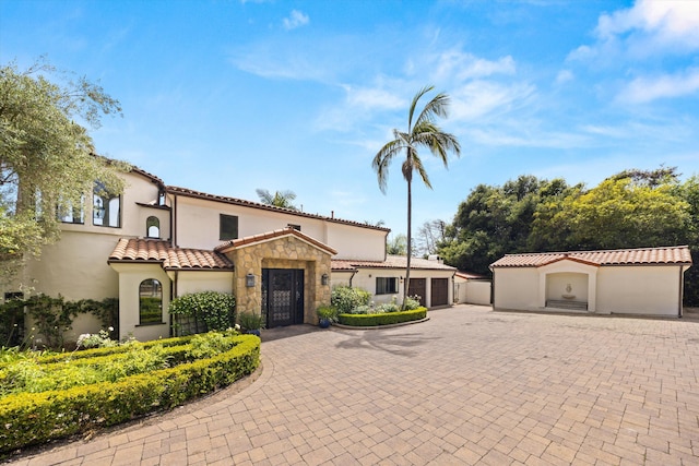 1151 Glenview Rd, Montecito, CA 93108 - mediterranean / spanish-style house with decorative driveway, stone siding, stucco siding, and a tile roof