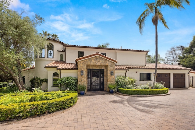 1151 Glenview Rd, Montecito, CA 93108 - mediterranean / spanish home featuring a garage, stucco siding, decorative driveway, and stone siding