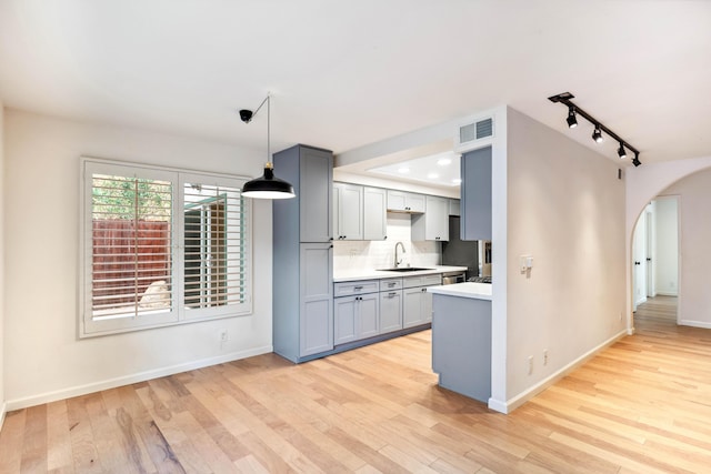 2624 State St # 1, Santa Barbara, CA 93105 - kitchen featuring arched walkways, light countertops, track lighting, light wood-type flooring, and gray cabinets