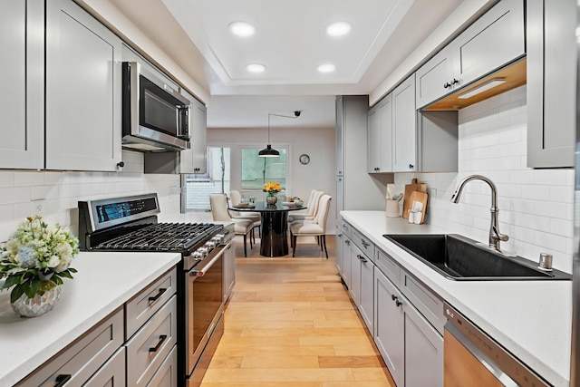 2624 State St # 1, Santa Barbara, CA 93105 - kitchen featuring stainless steel appliances, light wood finished floors, recessed lighting, a tray ceiling, and light countertops