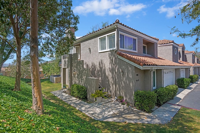 5965 Paseo Encantada, Camarillo, CA 93012 - view of home's exterior with stucco siding, a tile roof, a garage, and a yard