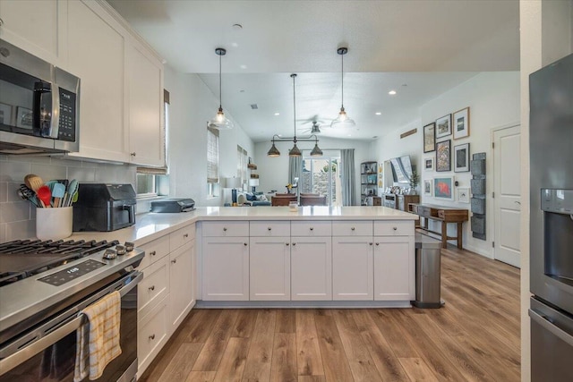 150 White Sage Ln, Lompoc, CA 93436 - kitchen featuring stainless steel appliances, a peninsula, light wood-style floors, decorative backsplash, and recessed lighting