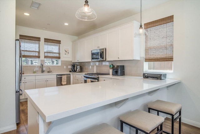 150 White Sage Ln, Lompoc, CA 93436 - kitchen featuring stainless steel appliances, a peninsula, tasteful backsplash, white cabinets, and dark wood-style floors