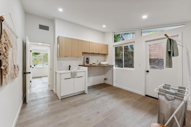 730 Meigs Rd, Santa Barbara, CA 93109 - kitchen with light wood finished floors, recessed lighting, baseboards, light brown cabinetry, and a sink