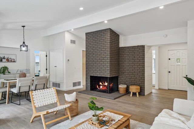 730 Meigs Rd, Santa Barbara, CA 93109 - living area with lofted ceiling, a brick fireplace, wood finished floors, recessed lighting, and baseboards