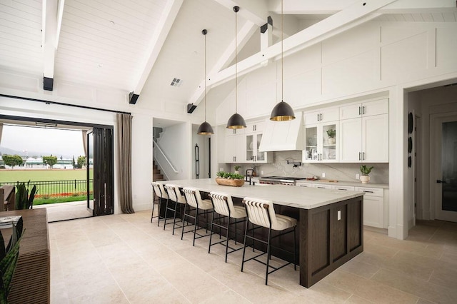 120 Polo Way, Carpinteria, CA 93013 - kitchen featuring white cabinetry, a breakfast bar area, a spacious island, pendant lighting, and high vaulted ceiling
