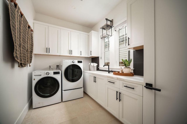 120 Polo Way, Carpinteria, CA 93013 - washroom featuring washing machine and clothes dryer, cabinet space, baseboards, and light tile patterned flooring