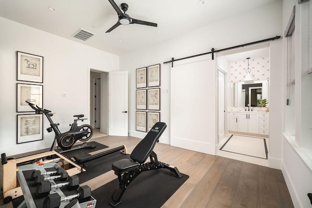 120 Polo Way, Carpinteria, CA 93013 - exercise area with a barn door, light wood-style floors, ceiling fan, and a sink