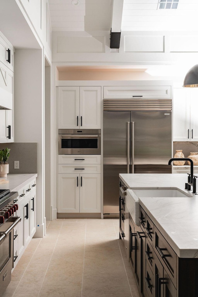 120 Polo Way, Carpinteria, CA 93013 - kitchen featuring light tile patterned floors, a sink, white cabinetry, and high quality appliances