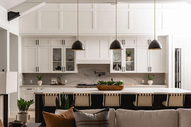 120 Polo Way, Carpinteria, CA 93013 - kitchen featuring tasteful backsplash, light countertops, white cabinets, glass insert cabinets, and lofted ceiling