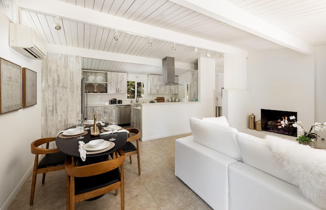 1067 E Mountain Dr, Santa Barbara, CA 93108 - living area featuring a wall mounted AC, beam ceiling, track lighting, a fireplace, and light tile patterned flooring