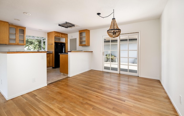 5003 Rhoads Ave, Santa Barbara, CA 93111 - kitchen with freestanding refrigerator, glass insert cabinets, light wood-style flooring, and brown cabinets