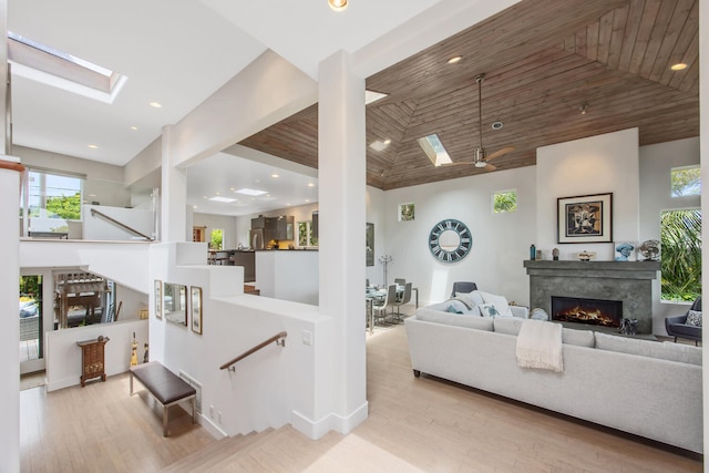 1312 Shoreline Dr, Santa Barbara, CA 93109 - living area featuring high vaulted ceiling, a skylight, a lit fireplace, plenty of natural light, and wood finished floors
