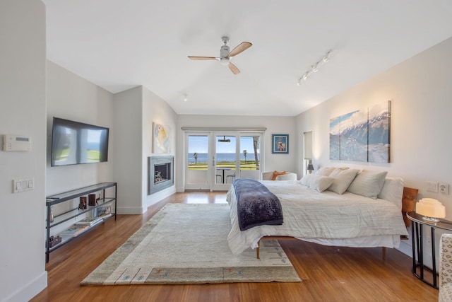 1312 Shoreline Dr, Santa Barbara, CA 93109 - bedroom featuring access to outside, wood finished floors, a fireplace, ceiling fan, and rail lighting