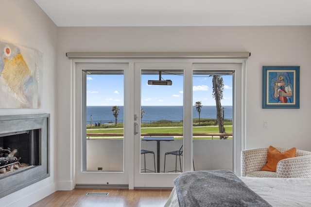 1312 Shoreline Dr, Santa Barbara, CA 93109 - bedroom with a water view, access to exterior, wood finished floors, and a fireplace