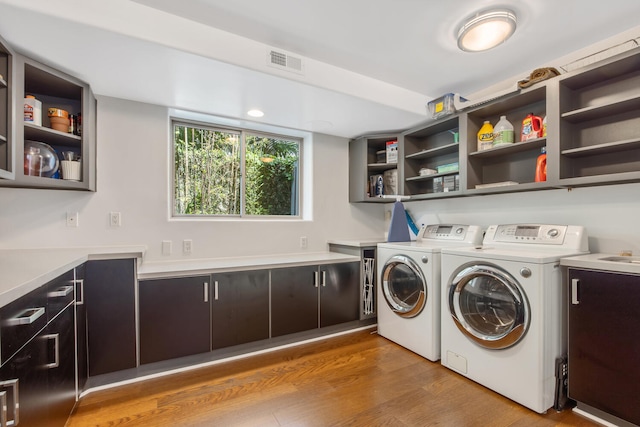 1312 Shoreline Dr, Santa Barbara, CA 93109 - laundry area with cabinet space, washing machine and dryer, and wood finished floors