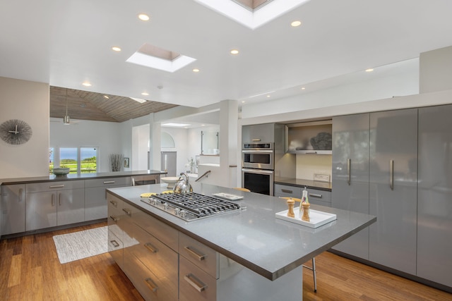 1312 Shoreline Dr, Santa Barbara, CA 93109 - kitchen with appliances with stainless steel finishes, modern cabinets, a skylight, wood finished floors, and gray cabinets