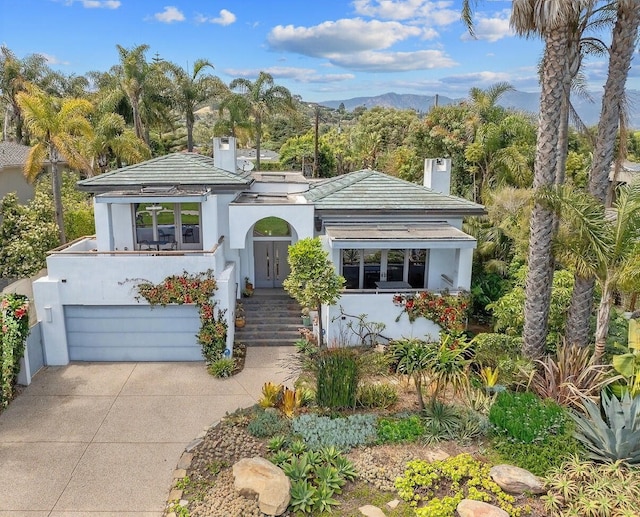 1312 Shoreline Dr, Santa Barbara, CA 93109 - view of front of house featuring concrete driveway, a garage, stucco siding, and a chimney