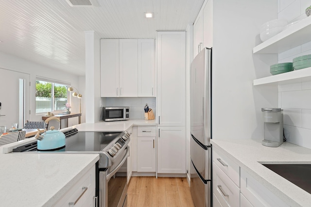 160 Ash Ave, Carpinteria, CA 93013 - kitchen featuring stainless steel appliances, white cabinets, light wood-style flooring, and tasteful backsplash