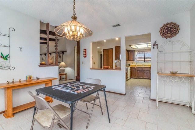 1300 E Airport Ave, Lompoc, CA 93436 - dining room featuring a chandelier, lofted ceiling, and light stone finish floors