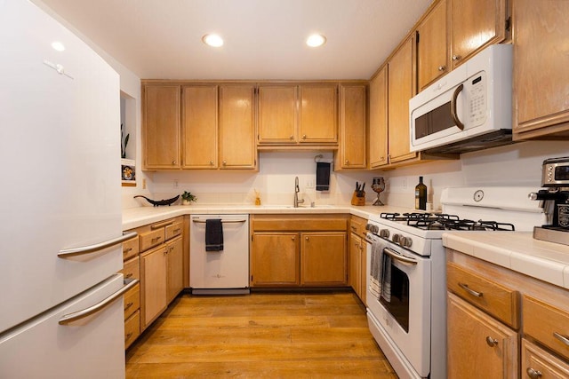 4515 Carpinteria Ave Unit G, Carpinteria, CA 93013 - kitchen with white appliances, light wood-style floors, tile countertops, and recessed lighting