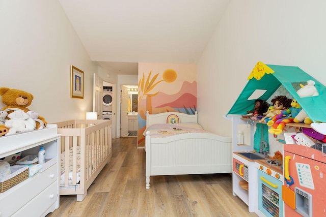 4515 Carpinteria Ave Unit G, Carpinteria, CA 93013 - bedroom featuring stacked washing machine and dryer and wood finished floors