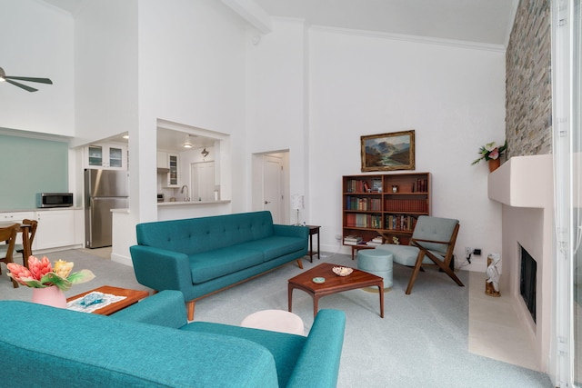 2206 Martinique Ln, Oxnard, CA 93035 - living area featuring light carpet, a ceiling fan, a towering ceiling, crown molding, and a large fireplace