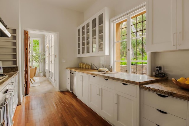 405 Toro Canyon Rd, Carpinteria, CA 93013 - kitchen with light wood finished floors, glass insert cabinets, stainless steel dishwasher, and white cabinetry