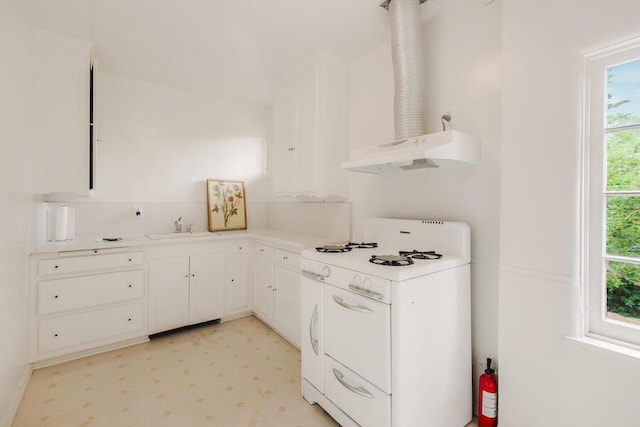 405 Toro Canyon Rd, Carpinteria, CA 93013 - kitchen with white range with gas stovetop, light floors, white cabinets, light countertops, and under cabinet range hood