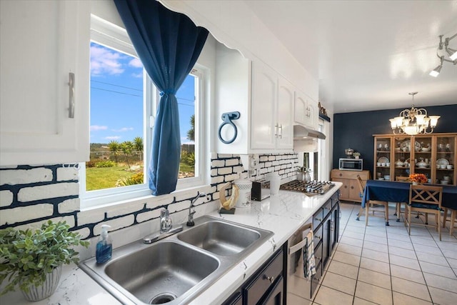 412 Milky Way, Lompoc, CA 93436 - kitchen with under cabinet range hood, white cabinets, a chandelier, stainless steel appliances, and tasteful backsplash
