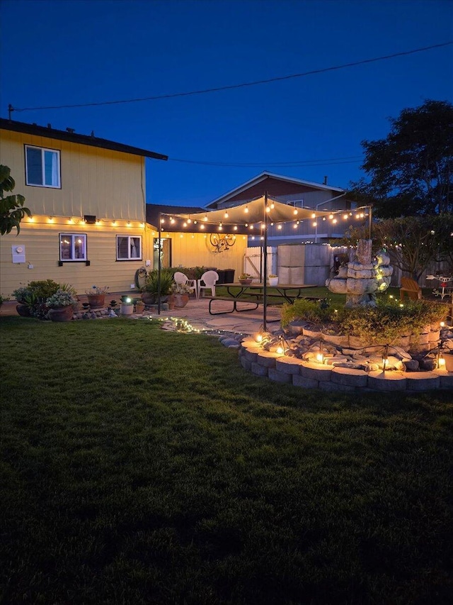 412 Milky Way, Lompoc, CA 93436 - yard at night with an outdoor fire pit, a lawn, and a patio area