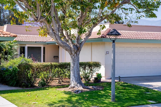 23 La Cumbre Cir, Santa Barbara, CA 93105 - view of front of house featuring a tile roof, a front lawn, stucco siding, concrete driveway, and an attached garage