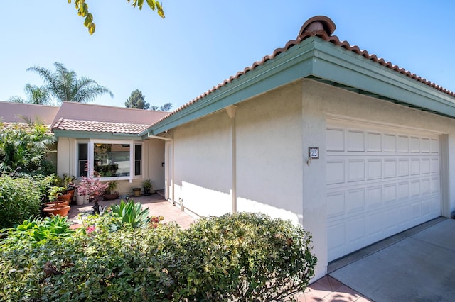23 La Cumbre Cir, Santa Barbara, CA 93105 - view of home's exterior featuring stucco siding, a tile roof, concrete driveway, and an attached garage