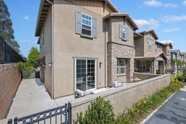 6594 Pipeline Pl, Goleta, CA 93117 - view of side of property with stone siding, stucco siding, a fenced front yard, and a residential view