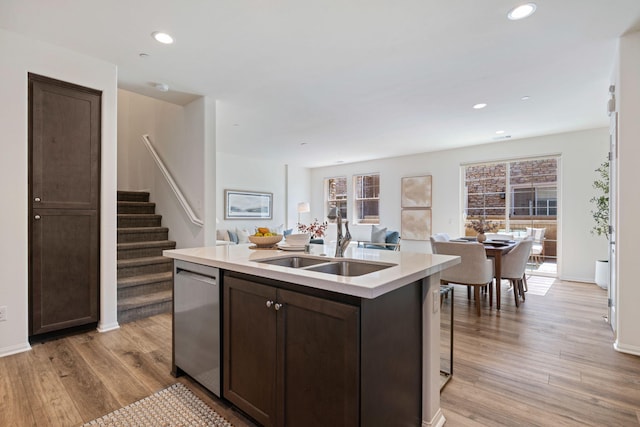 6594 Pipeline Pl, Goleta, CA 93117 - kitchen featuring dishwasher, dark brown cabinetry, a center island with sink, open floor plan, and light wood-style floors