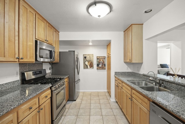 2171 Martinique Ln, Oxnard, CA 93035 - kitchen featuring stainless steel appliances, dark stone counters, and light tile patterned floors