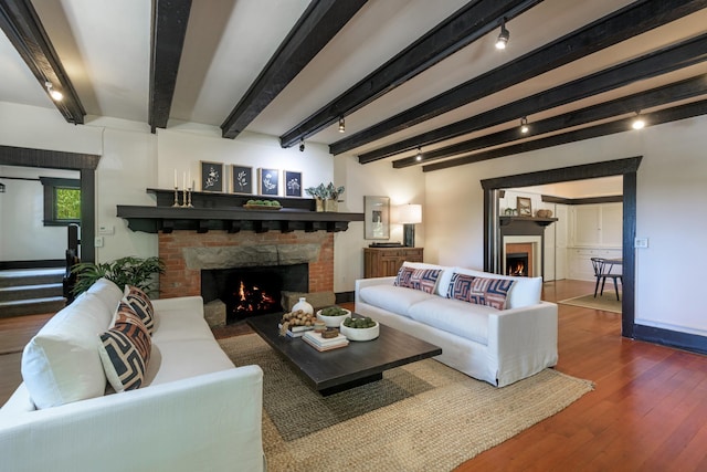 435 E Pedregosa St, Santa Barbara, CA 93101 - living room with a warm lit fireplace, track lighting, hardwood / wood-style floors, beam ceiling, and stairs